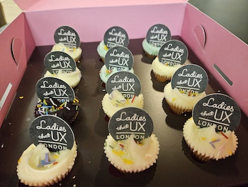 Photo shows a box full of mini cupcakes.  All in pastal colours, iced with the LTUX London logo on top